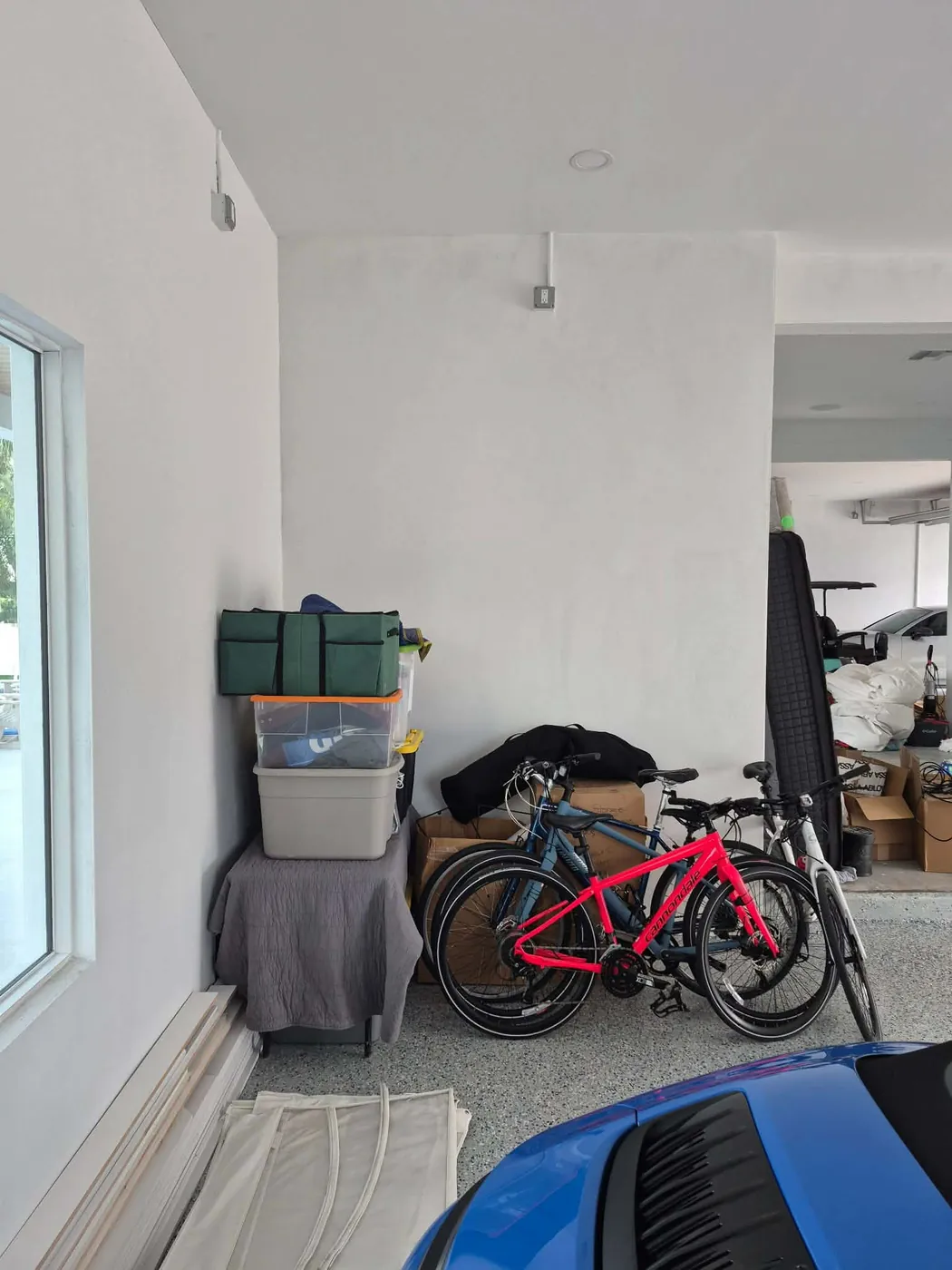 Garage storage before in Ozona, FL — bikes and bins crowding the floor